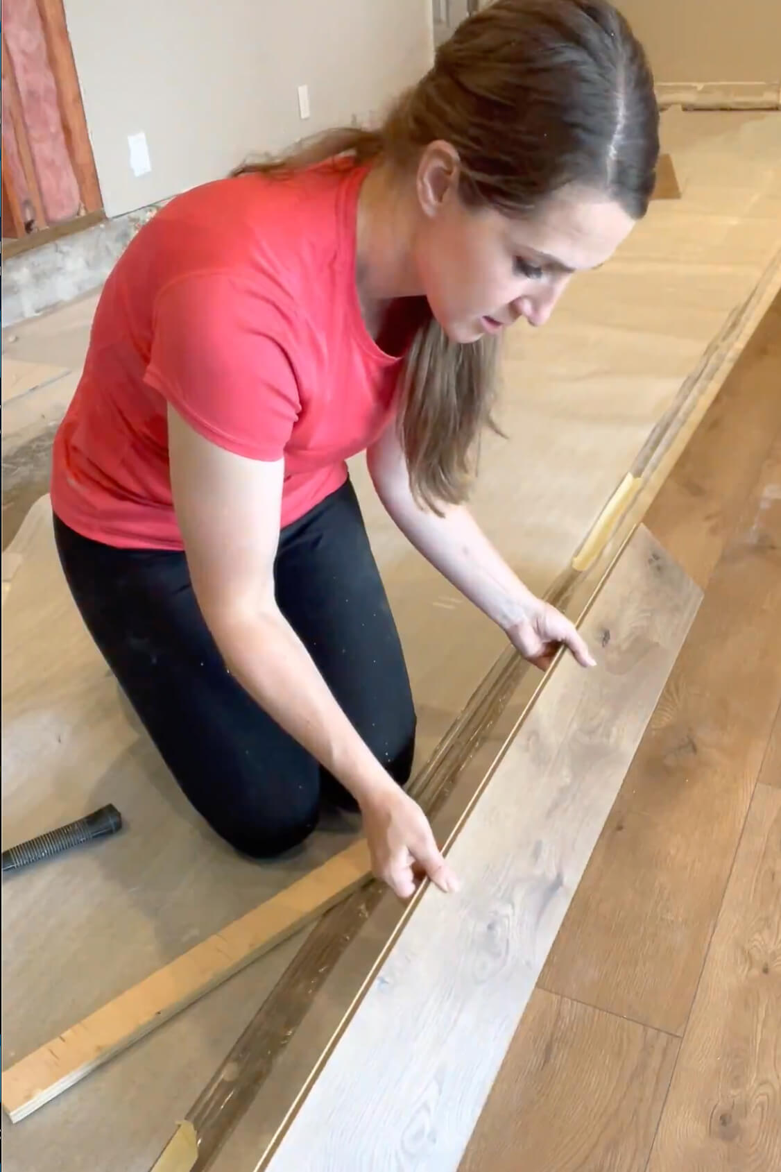 Demonstrating how to lock laminate flooring planks together.